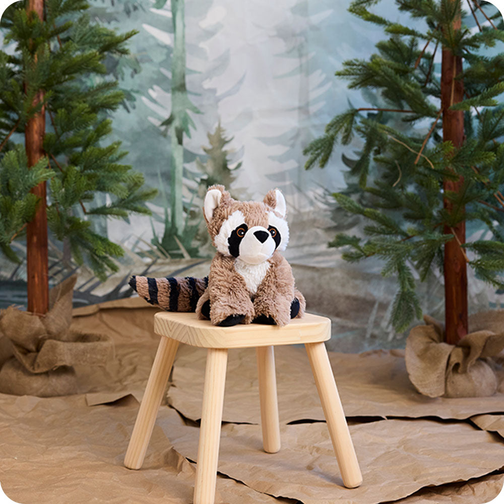 Image 107: raccoon stuffed animal sitting on a stool in woodland setting