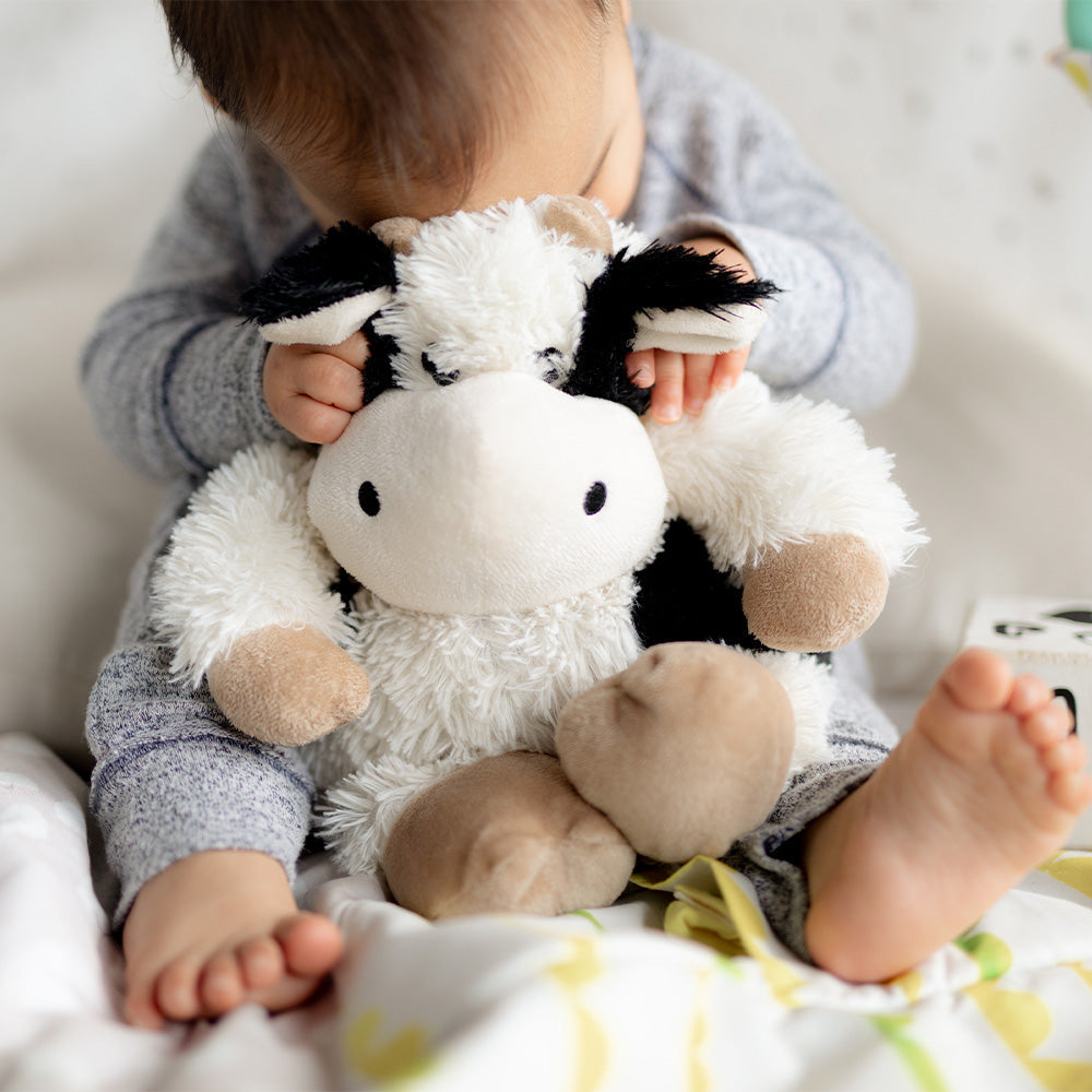 Image 104: Baby cuddling Soft Lavender Scented Black and White Cow Warmies