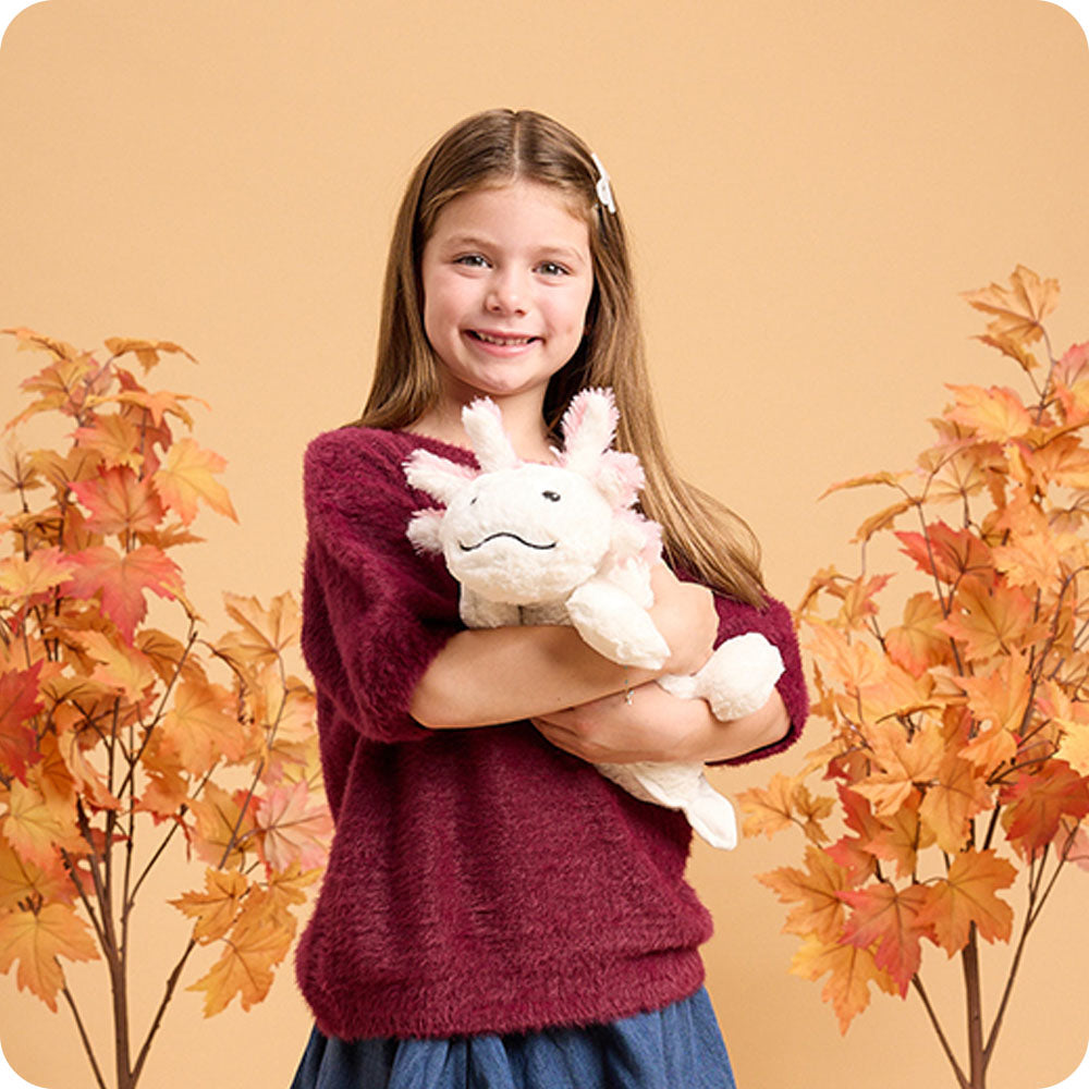 Image 103: girl holding white axolotl warmies autumn lifestyle