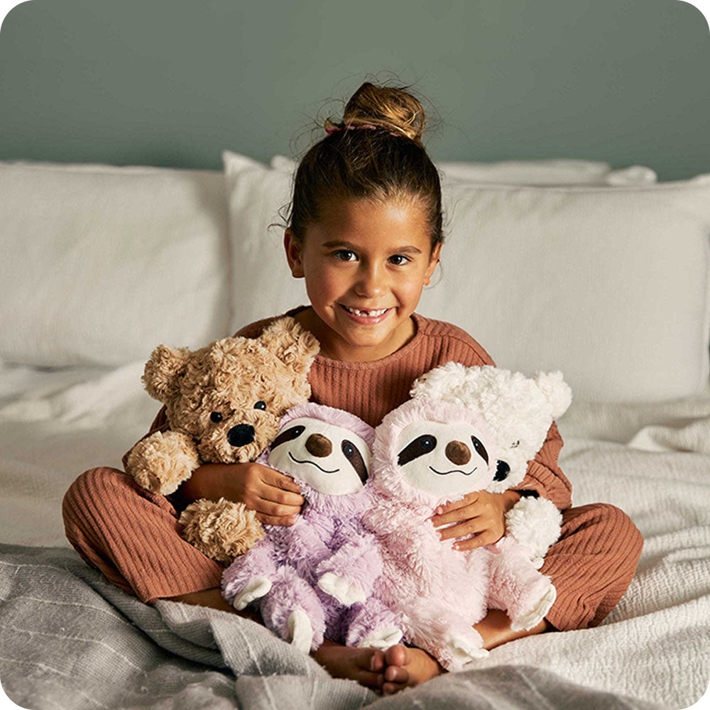 Image 104: little girl hugging sloth stuffed animal warmies