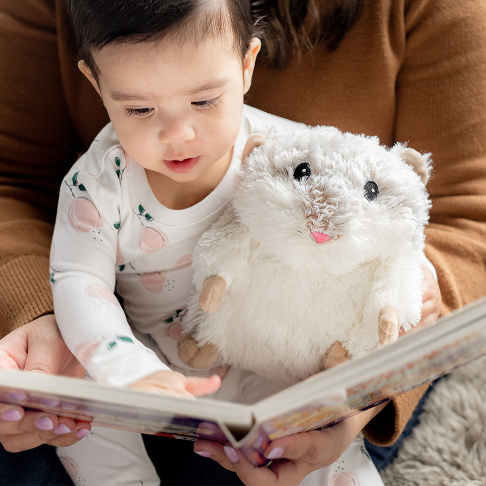 Image 103: Mom and baby boy reading book with Cute Weighted Lavender Scented Hamster Stuffed Animal Heating Pad Warmies