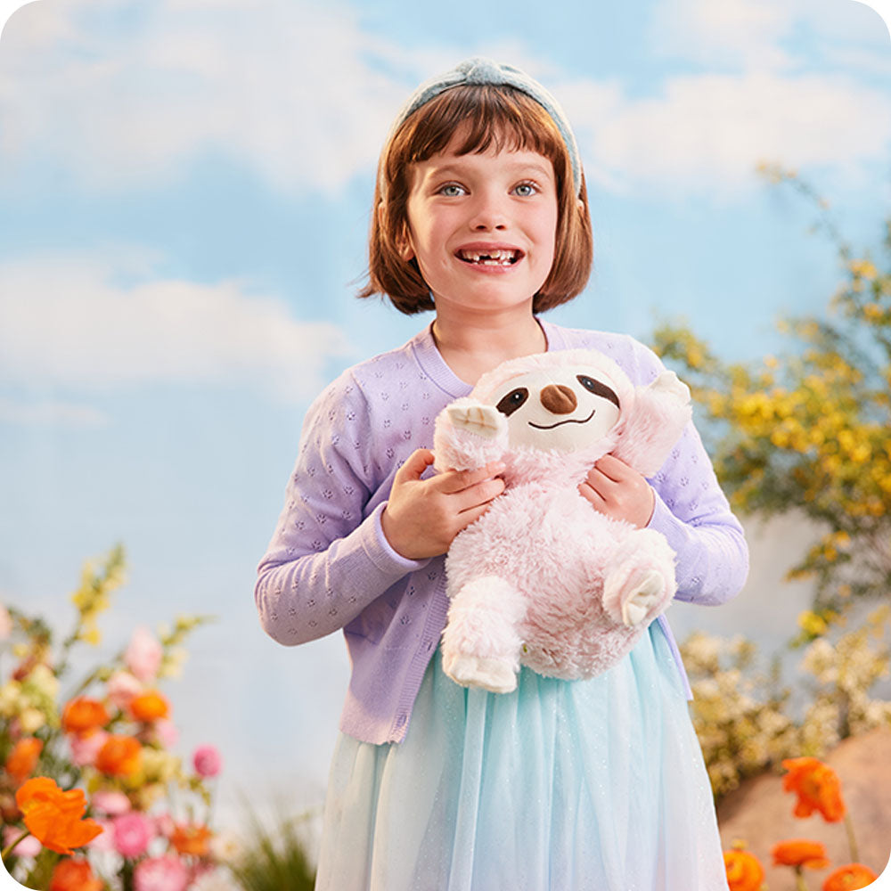Image 102: little girl hugging pink sloth stuffed animal warmies