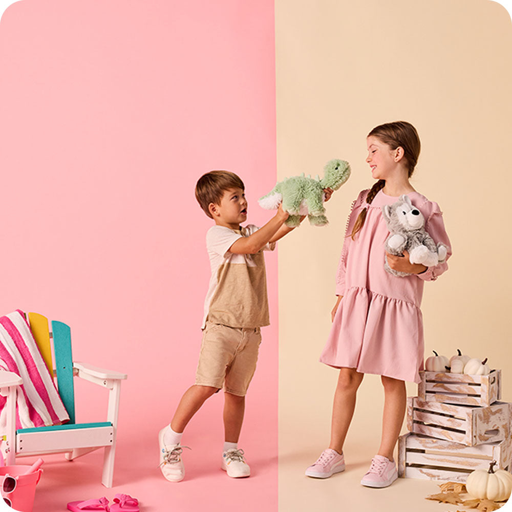Image 100: boy holding green long neck dino stuffed animal