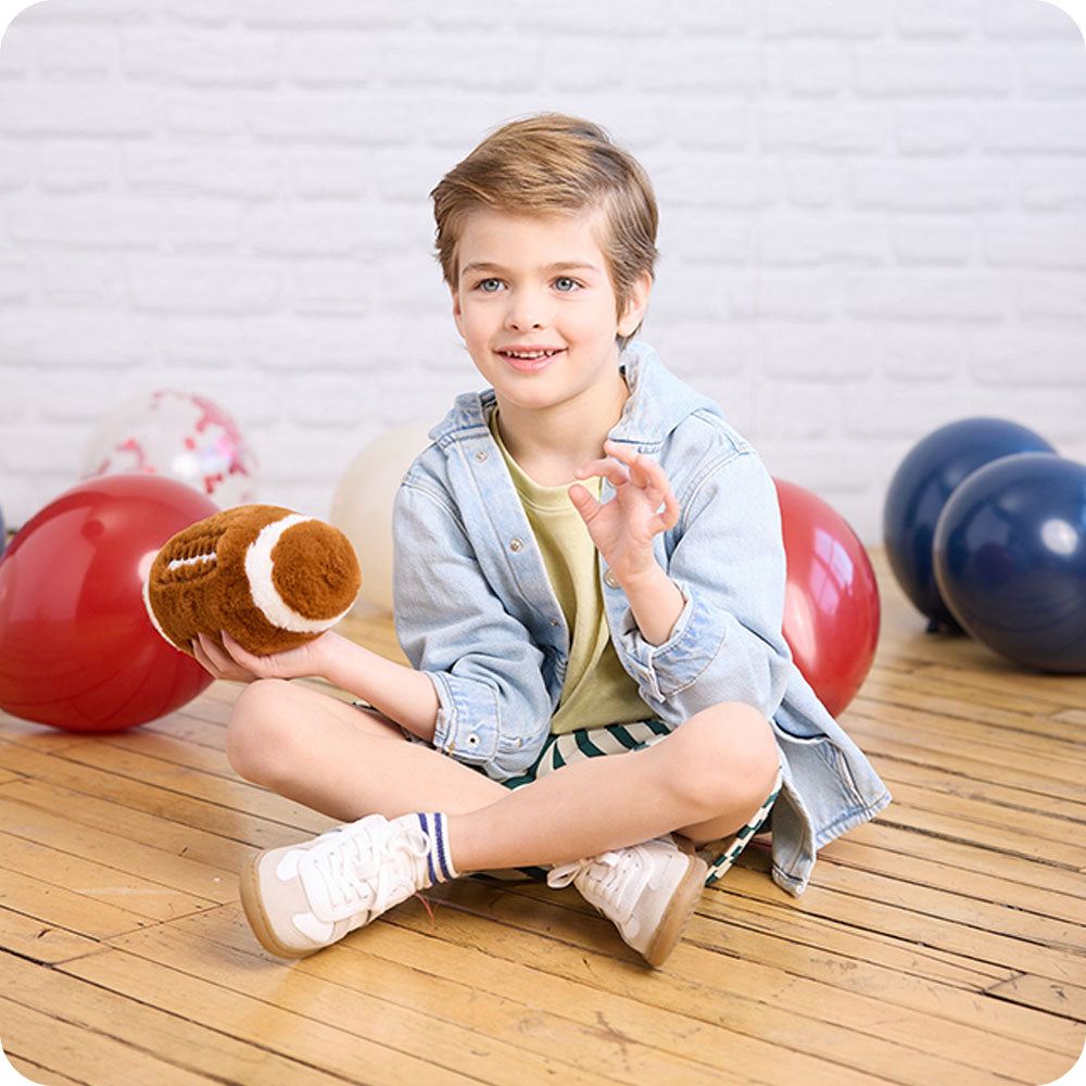 Image 96: boy holding football stuffed animal