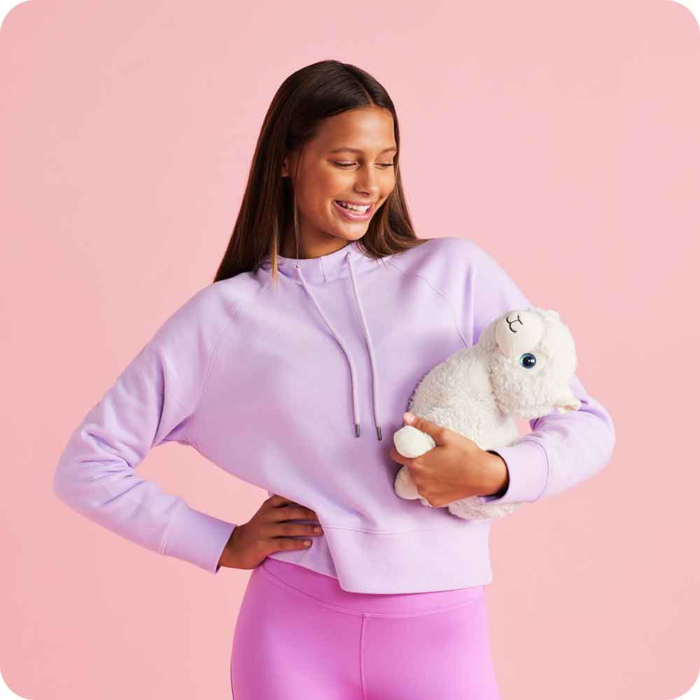 Image 100: Teen girl smiling and holding Soft Warm Weighted Llama Plush Warmies
