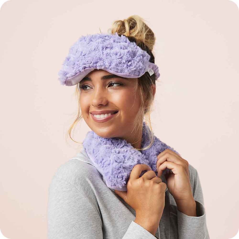 Image 88: Woman smiling while wearing Microwavable Curly Purple Warmies Eye Mask
