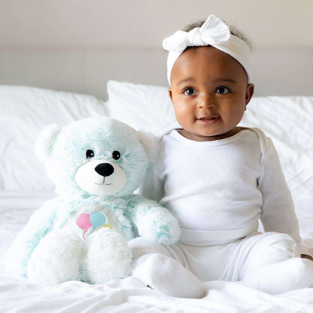 Image 101: Baby sitting next to Cute Weighted Lavender Scented Celebration Bear Stuffed Animal Heating Pad Warmies