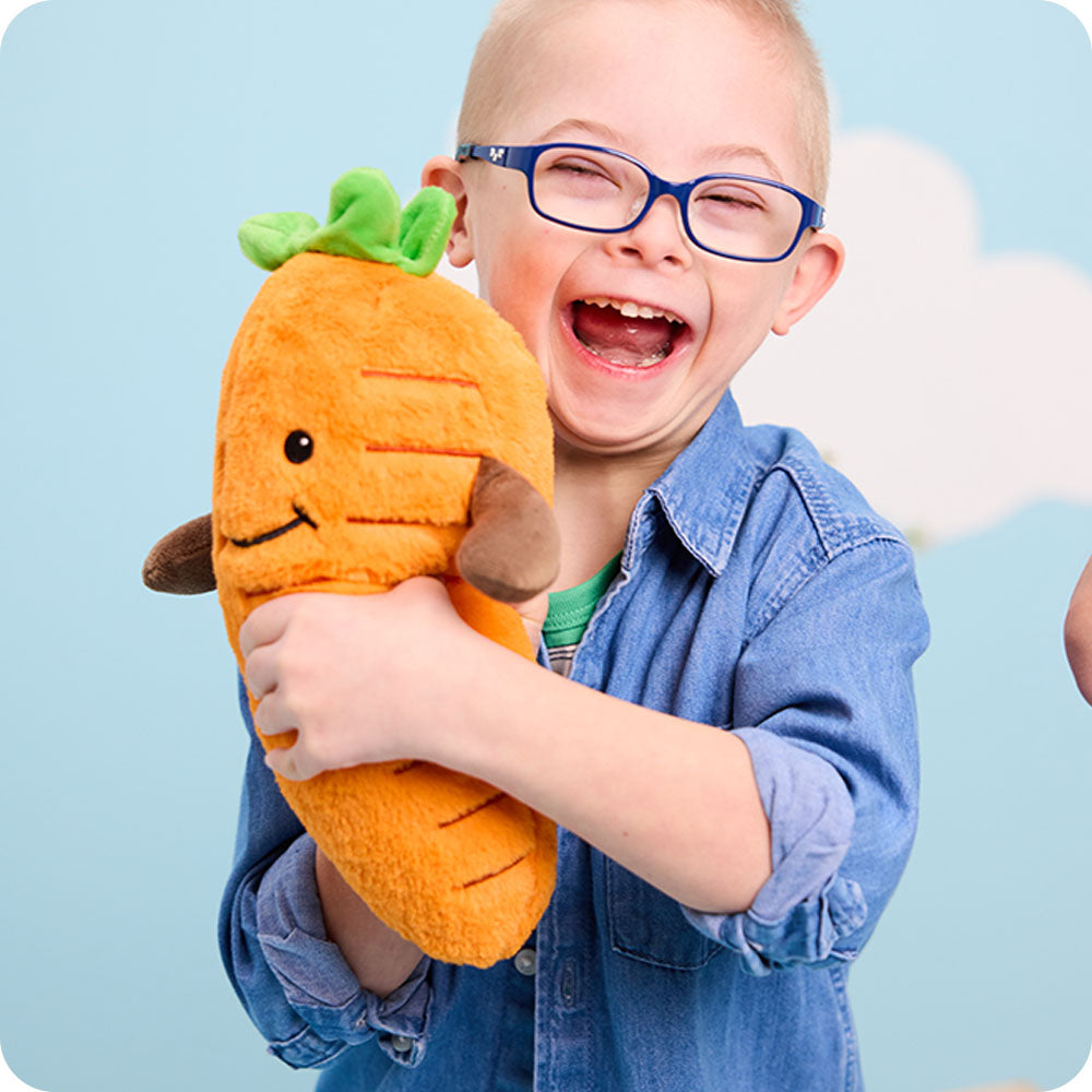 Image 100: boy holding carrot stuffed animal warmies