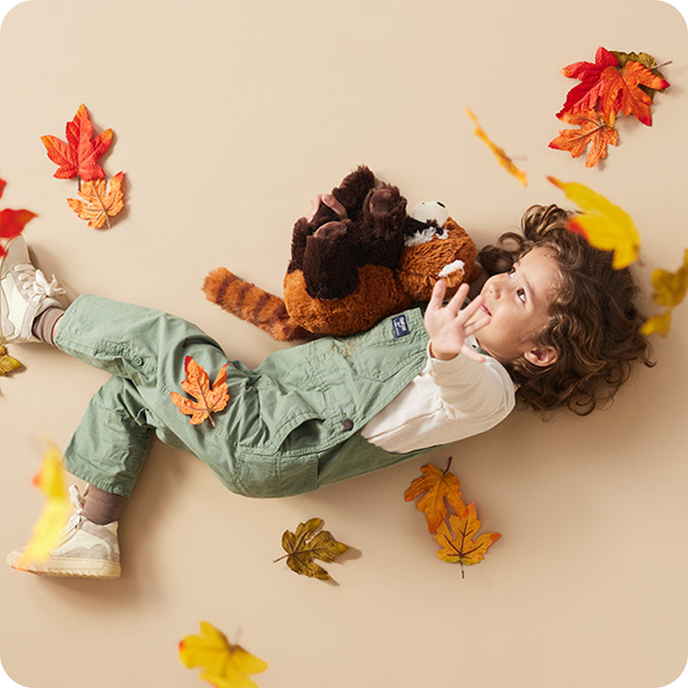 Image 101: girl holding red panda stuffed animal warmies in autumn setting
