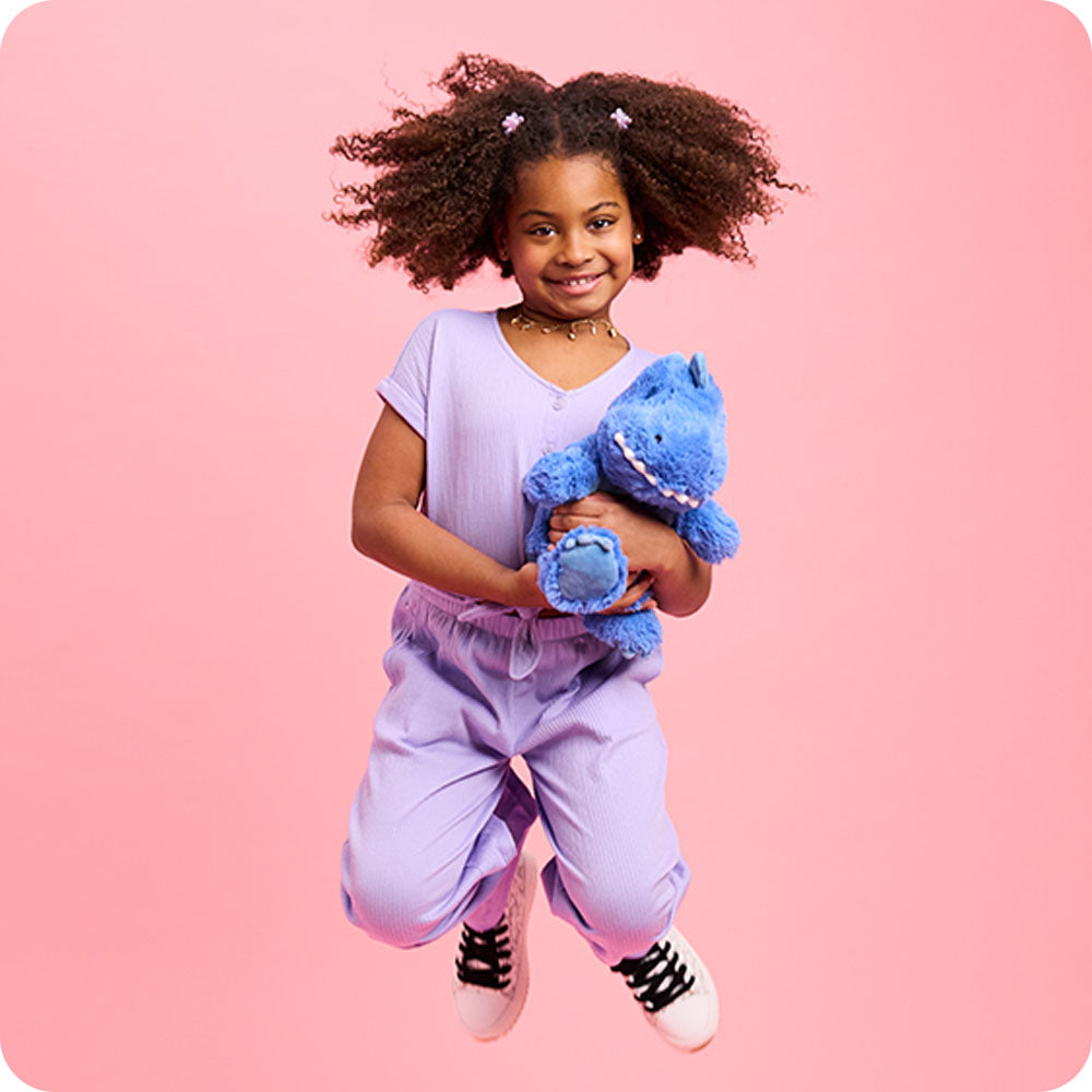 Image 101: girl jumping with t rex stuffed animal warmies