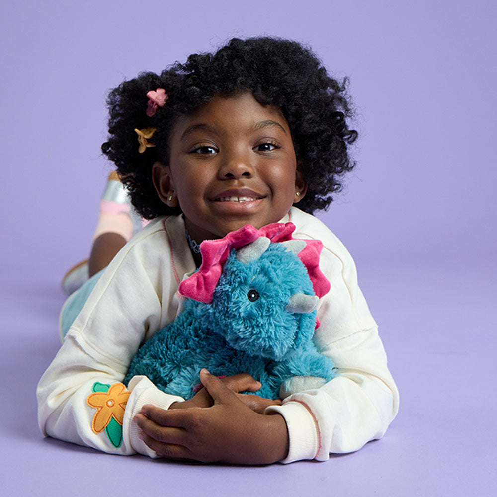 Image 103: girl hugging triceratops stuffed animal warmies