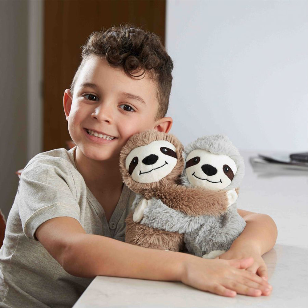 Image 100: Little boy smiling and hugging Warm Weighted Lavender Scented Sloth Hugs Plush Warmies