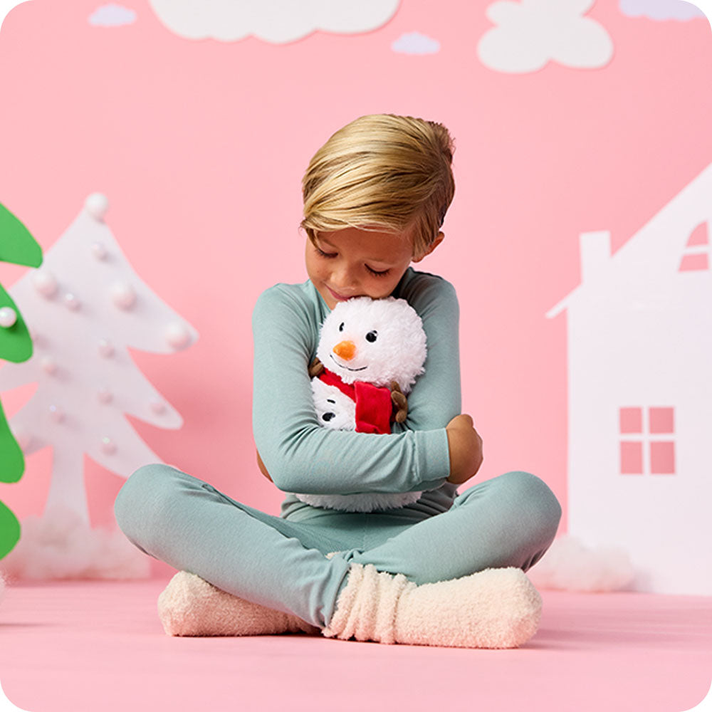 Image 100: boy hugging snowman stuffed animal