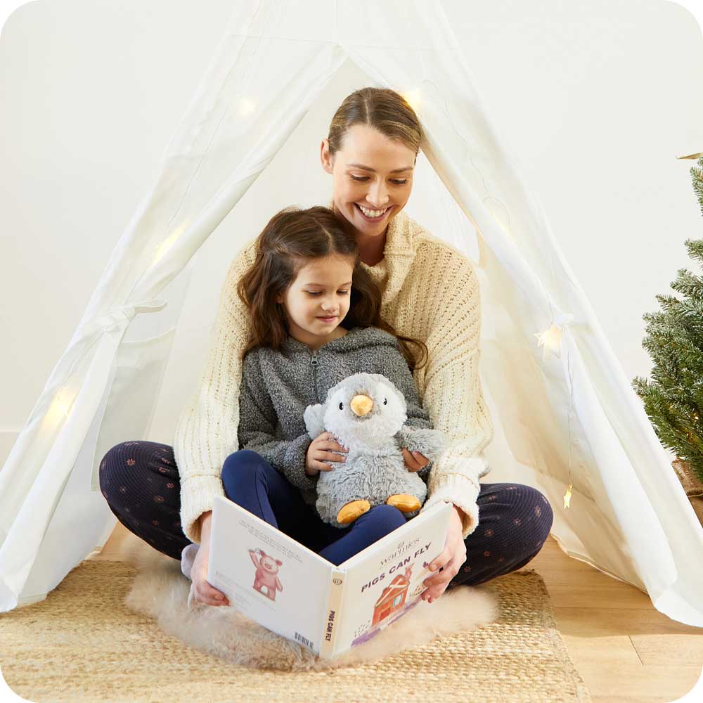 Image 96: Mother and daughter reading a book with Soft Warm Weighted Gray Penguin Plush Warmies