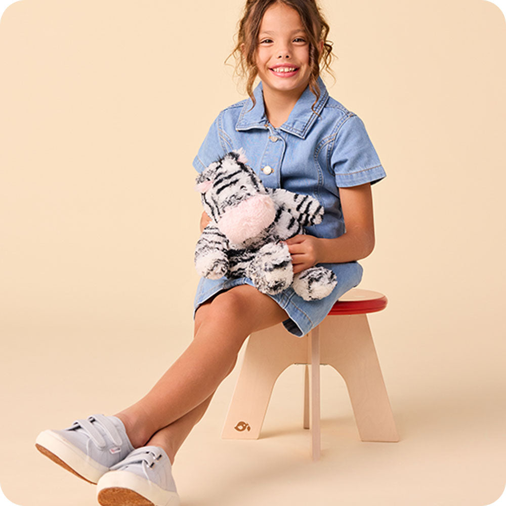 Image 101: girl hugging zebra stuffed animal warmies