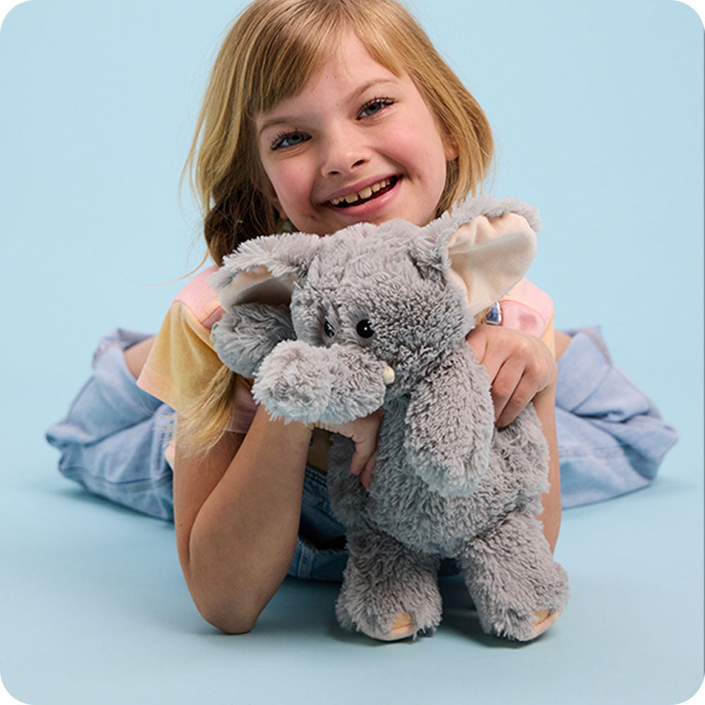 Image 101: girl holding a warmies elephant stuffed animal