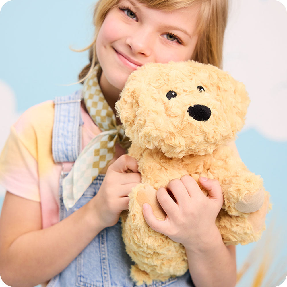 Image 99: girl holding golden dog warmies stuffed animals