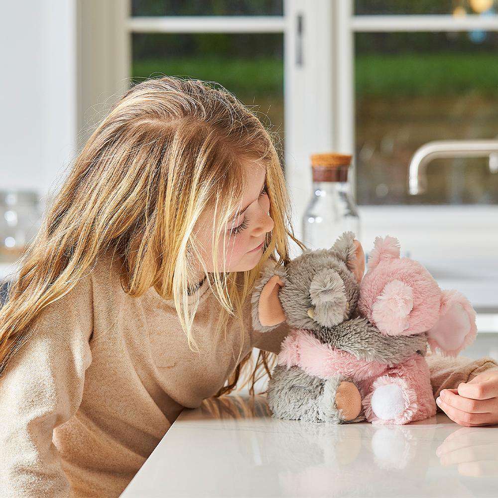 Image 98: Child smiling and looking at Cute Weighted Lavender Scented Elephant Hugs Stuffed Animal Heating Pad Warmies