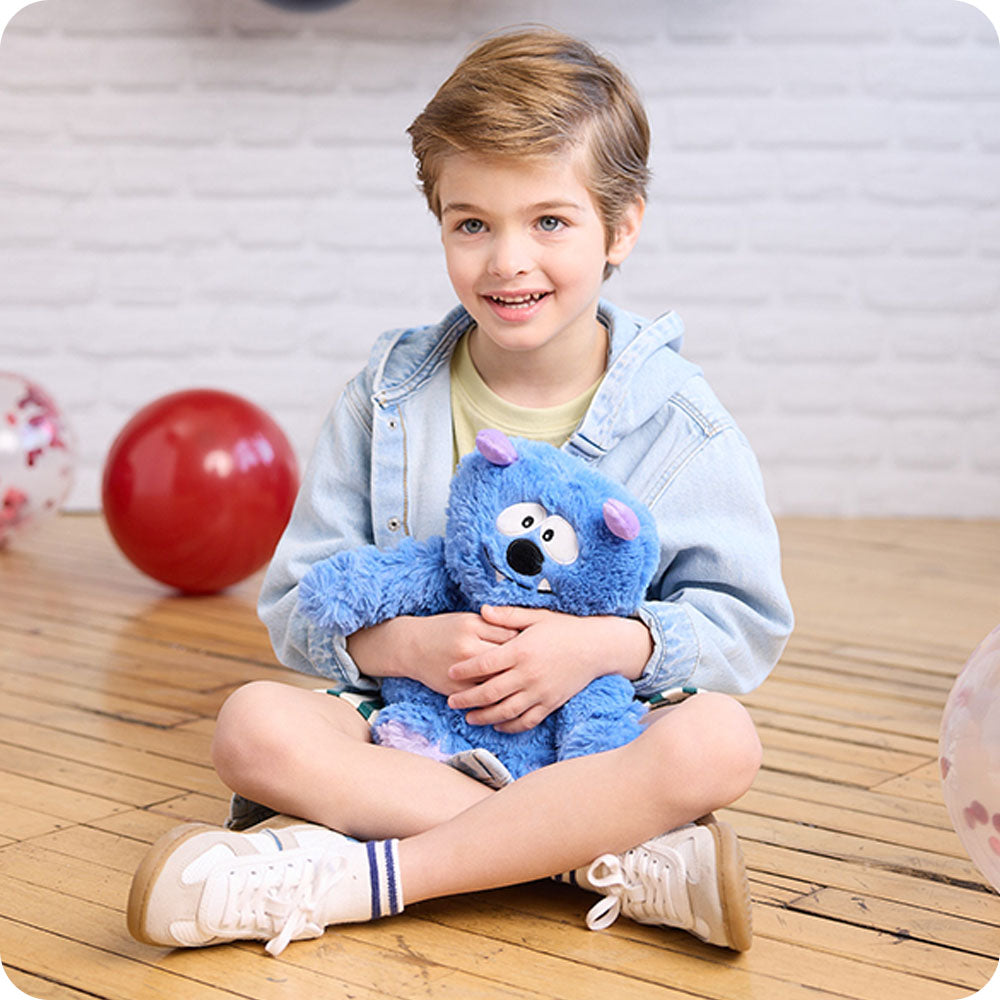 Image 104: boy holding blue monster stuffed animal