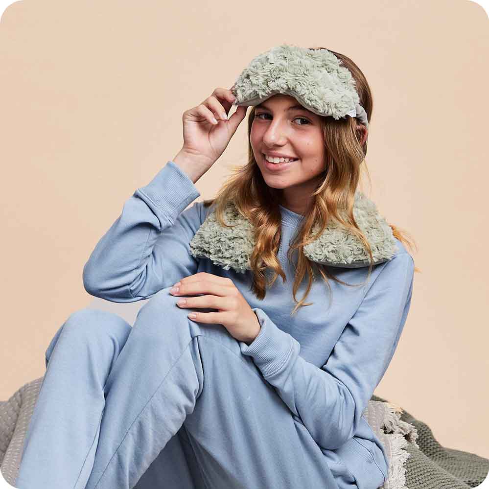 Image 88: Teen smiling while wearing Lavender Scented Microwavable Curly Sage Green Warmies Neck Wrap