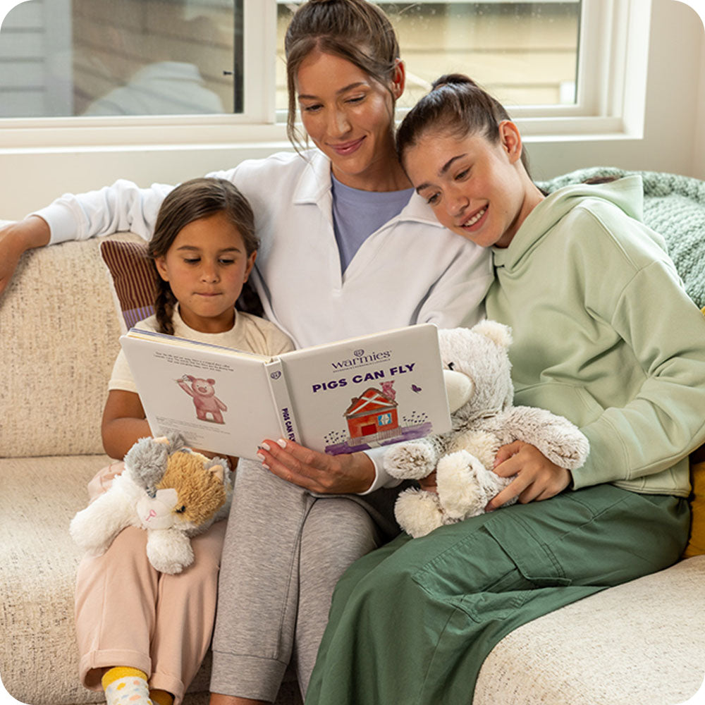 Image 93: family reading pigs can fly warmies book