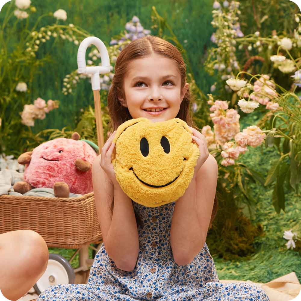 Image 103: Girl holding and playing with Cute Weighted Lavender Scented Smiley Face Stuffed Animal Heating Pad Warmies