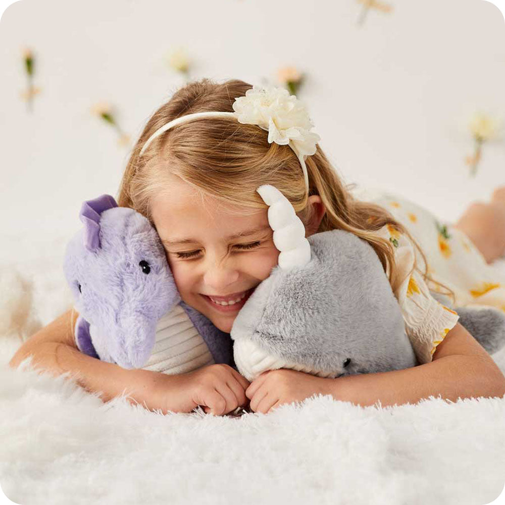 Image 101: girl cuddling seahorse and narwhal stuffed animals