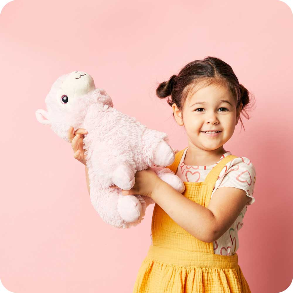 Image 98: Little girl holding Soft Warm Weighted Pink Llama Plush Warmies