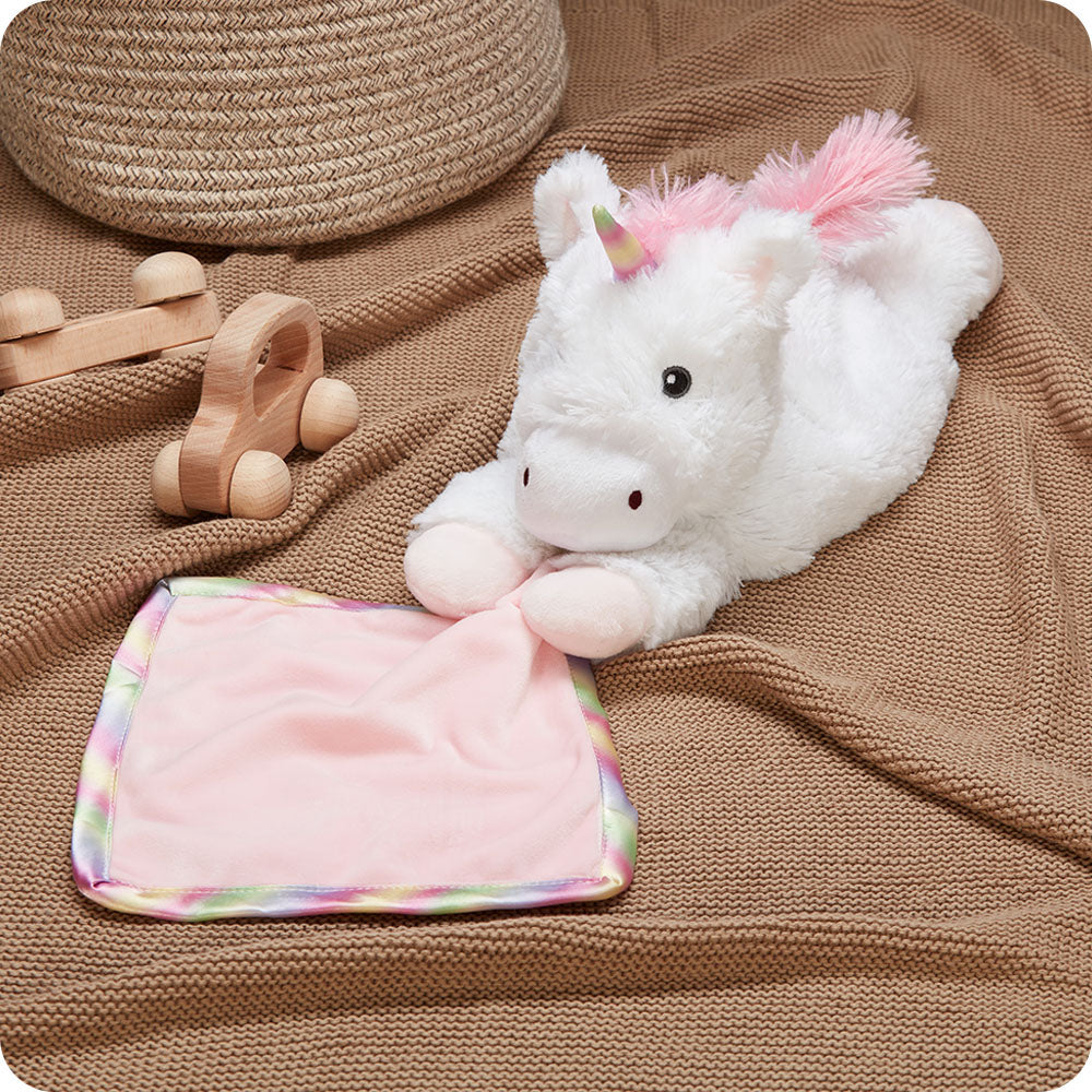 Image 92: warmies unicorn blankie on a kids blanket with toys