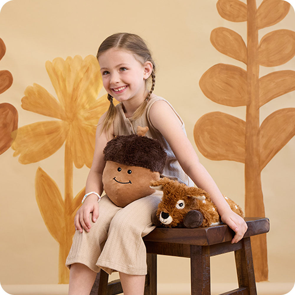 Image 102: girl sitting on bench with laying down deer stuffed animal warmies