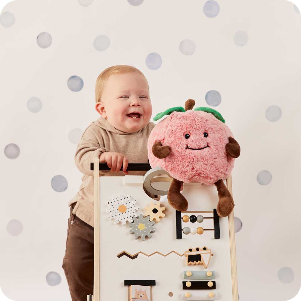 Image 103: Toddler laughing and holding a Cute Weighted Lavender Scented Red Apple Stuffed Animal Heating Pad Warmies