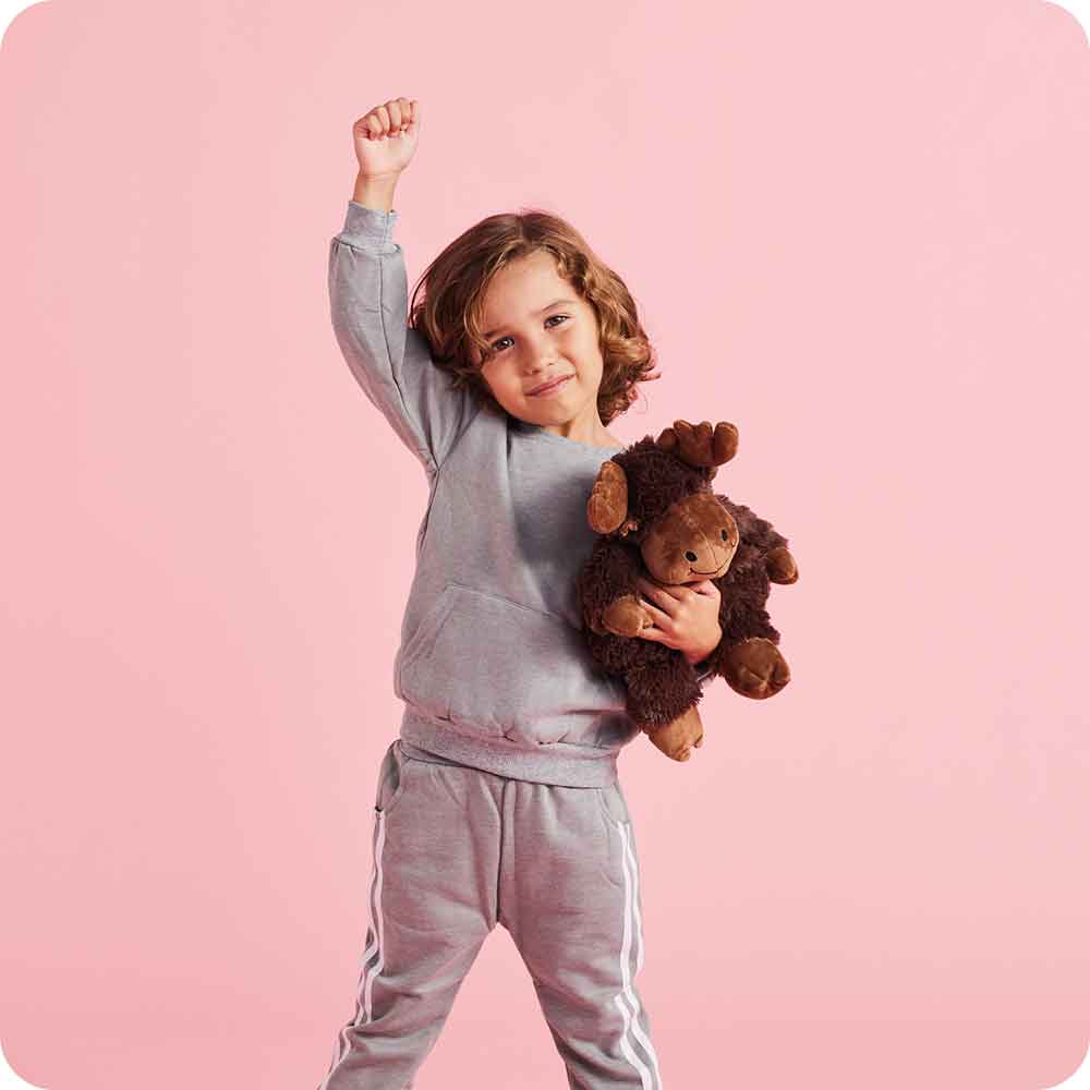 Image 100: Little boy standing up and holding Soft Warm Weighted Moose Plush Warmies