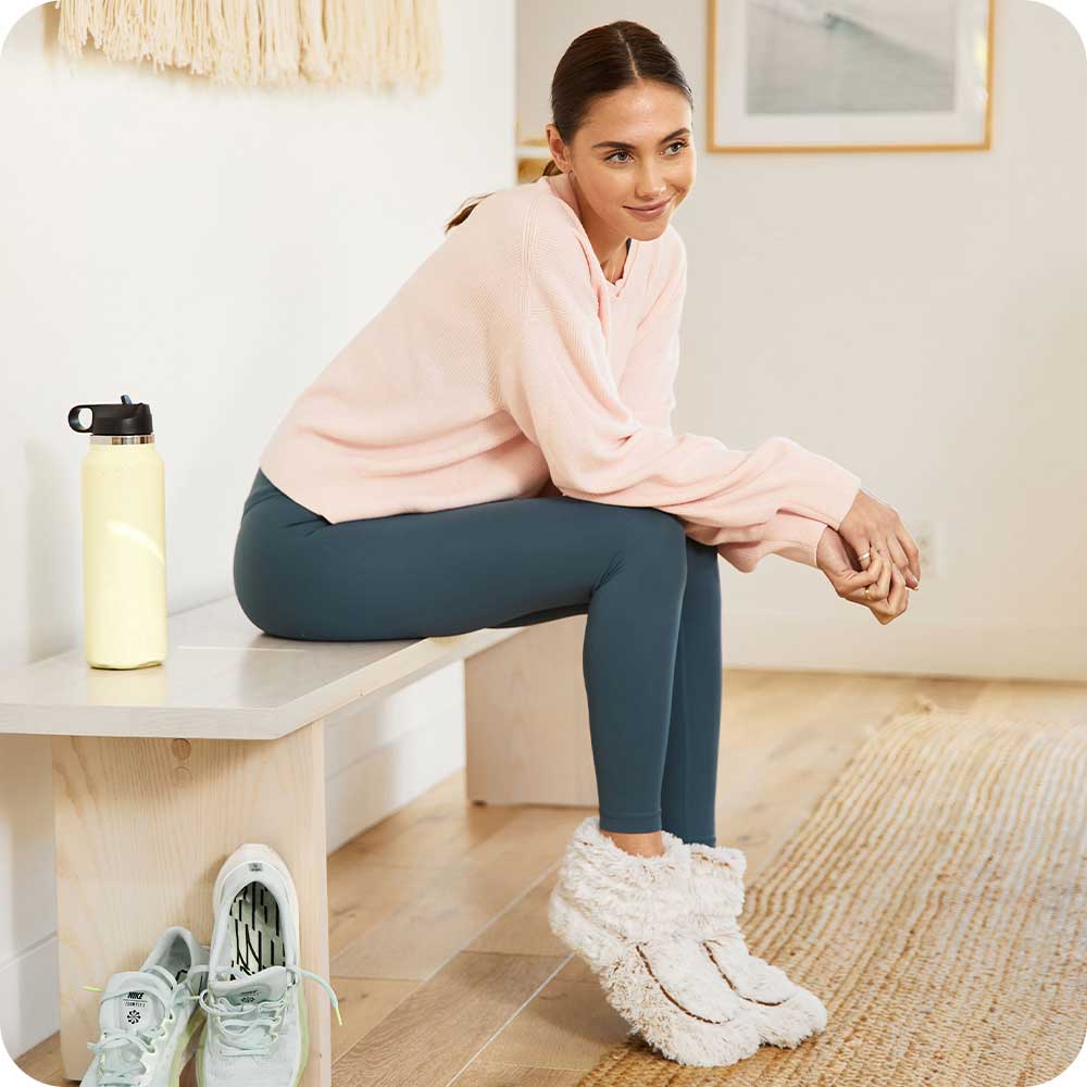 Image 95: Woman sitting down and wearing Cozy Microwavable Brown Warmies Boots.
