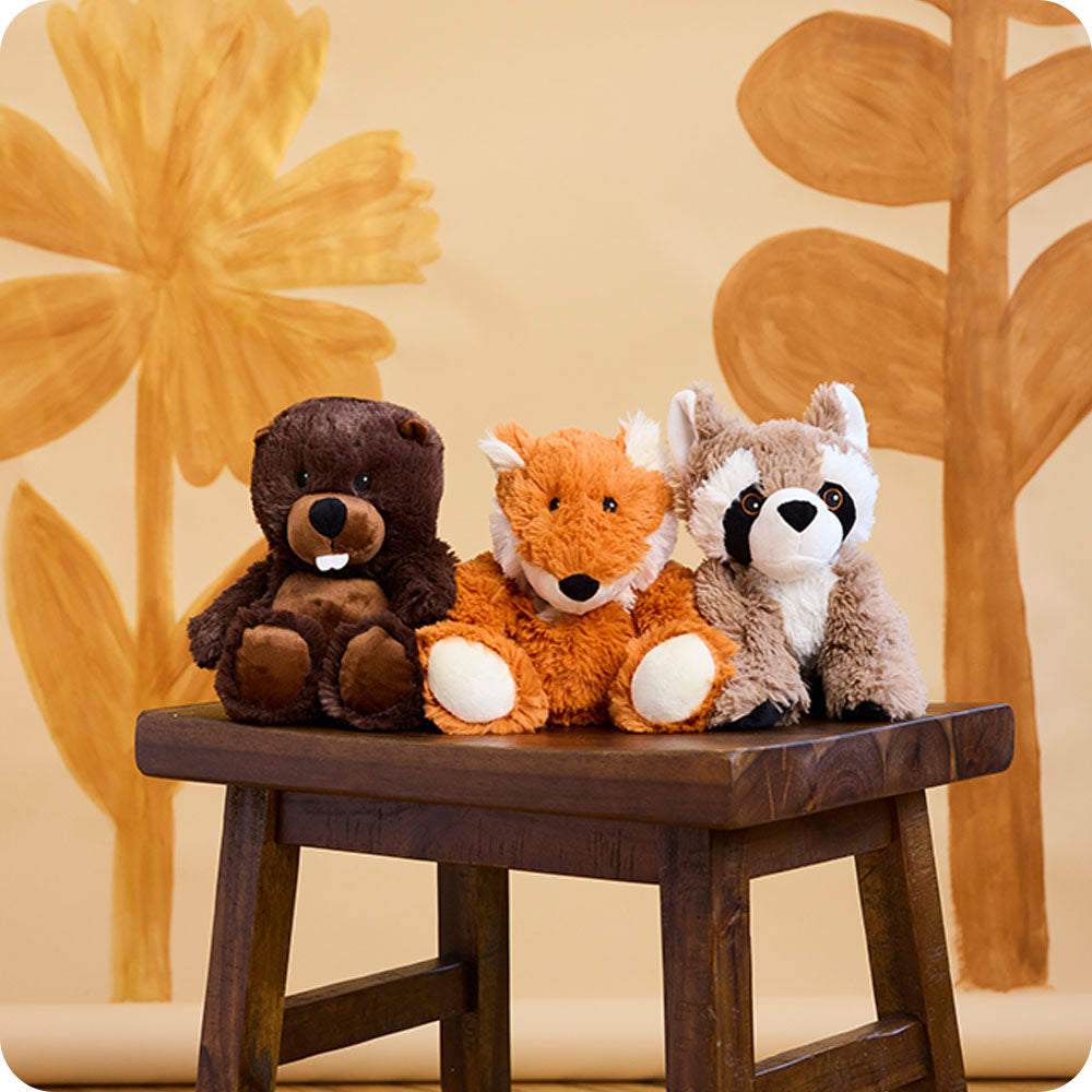 Image 99: beaver, fox, and raccoon stuffed animal warmies on a bench